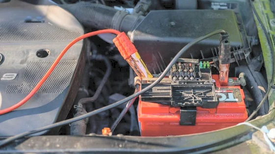 A technician testing a car battery.